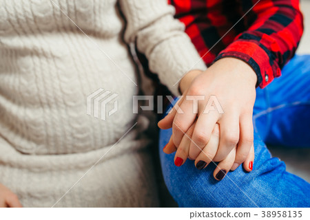 Close-up view of the future parents holding hands 38958135