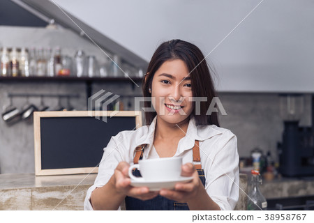 Young female barista and her small shop. Young female barista and her small shop. 38958767