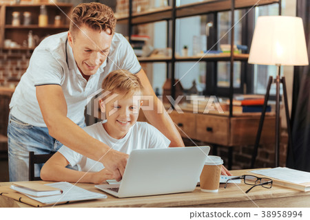 Nice positive man pointing at the laptop screen Nice positive man pointing at the laptop screen 38958994