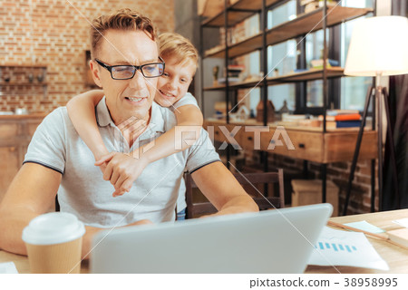 Positive cute boy hugging his father 38958995