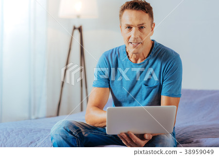 Positive handsome man holding a netbook 38959049