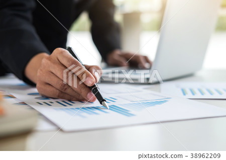 Female accountant calculations and analyzing financial graph dat 38962209