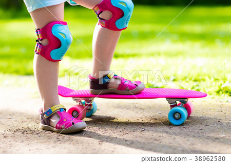 Child riding skateboard in summer park Child riding skateboard in summer park 38962580