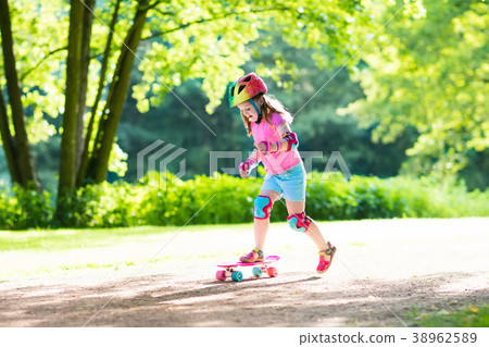 Child riding skateboard in summer park Child riding skateboard in summer park 38962589