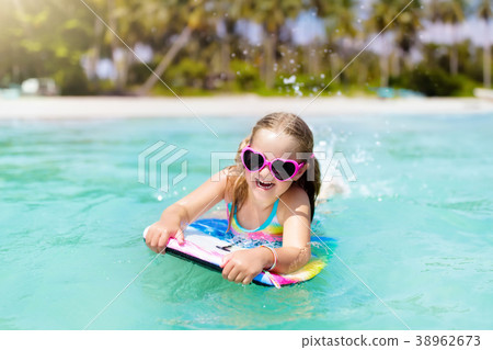 Kids surf on tropical beach. Vacation with child. 38962673