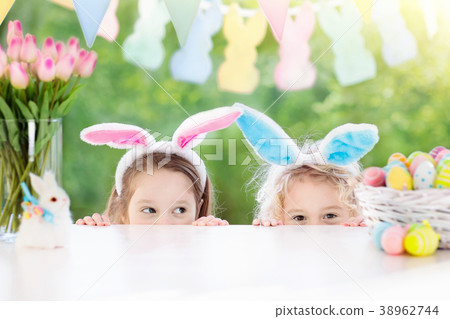 Kids with bunny ears and eggs on Easter egg hunt. 38962744