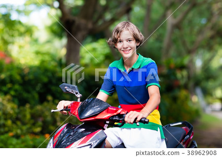 Teenager riding scooter. Boy on motorcycle. Teenager riding scooter. Boy on motorcycle. 38962908