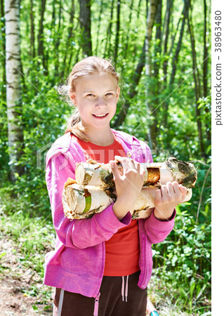 Young girl carries firewood from forest Young girl carries firewood from forest 38963480