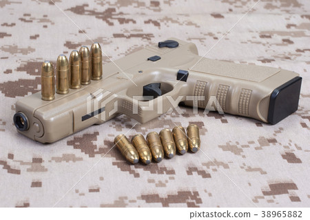 handgun on camouflage uniform 38965882
