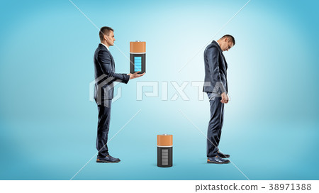 A businessman brings a large fully charged battery A businessman brings a large fully charged battery 38971388