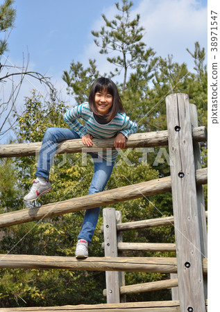 Girls playing with park play equipment 38971547