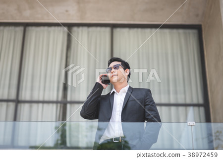 Smart Asian businessman talking with phone 38972459