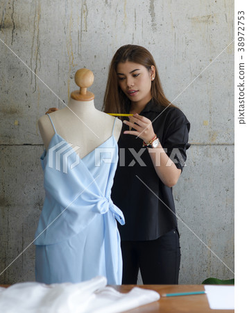 Asian female clothing designer using dress dummy, 38972753