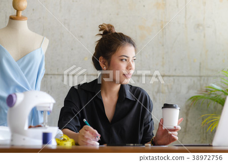 Fashion designer drinking coffee and looking out  38972756
