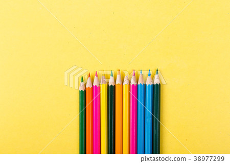 Colorful pencils on yellow background. 38977299