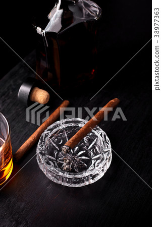 Glass of whiskey with smoking cigar. 38977363