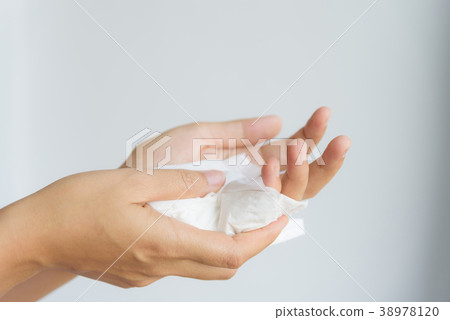 Woman cleaning her hands by using white tissue  38978120