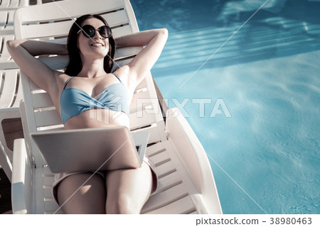 Extremely happy brunette sunbathing and smiling Extremely happy brunette sunbathing and smiling 38980463