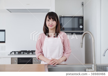 A woman standing in the kitchen A woman standing in the kitchen 38980466