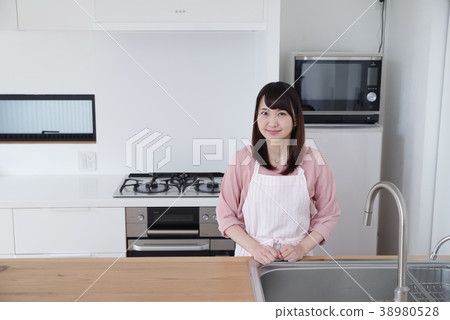 一個女人站在廚房裡 一個女人站在廚房裡 38980528