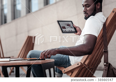 Millennial businessman working on touchpad Millennial businessman working on touchpad 38980547