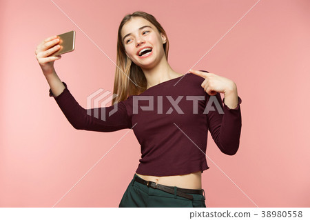 Cute brunette girl takes a selfie. She smiles Cute brunette girl takes a selfie. She smiles 38980558