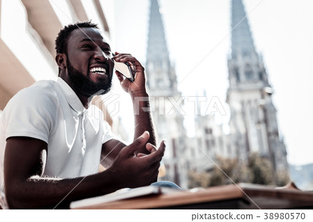 Extremely happy young man laughing while talking 38980570