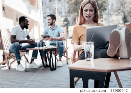 Enthusiastic young lady working on laptop outdoors 38980942