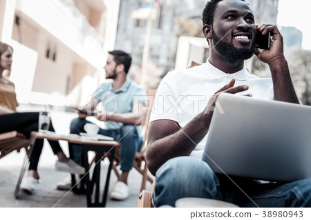 Radiant millennial guy talking on phone and Radiant millennial guy talking on phone and 38980943