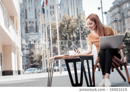 Cheerful woman reading message and smiling Cheerful woman reading message and smiling 38981019