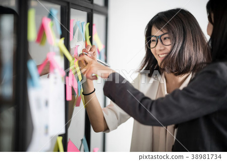 Businesspeople putting their ideas at sticky notes 38981734