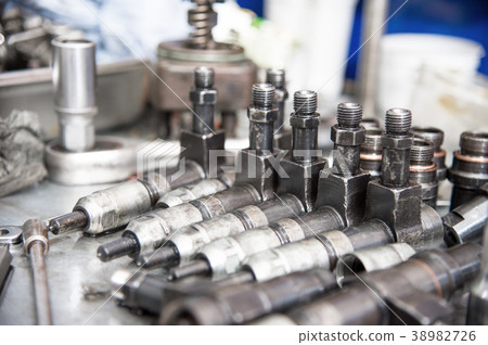 Old diesel injectors lie on the table in the fuel 38982726