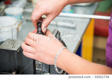 Male hands dismantle a mechanical diesel nozzle to Male hands dismantle a mechanical diesel nozzle to 38982798