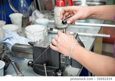 Male hands dismantle a mechanical diesel nozzle to 38982834