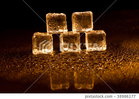 Golden ice cubes on black background. 38986177