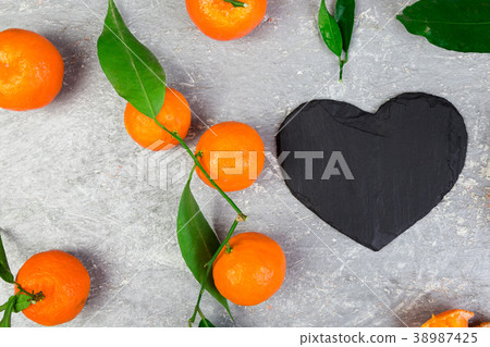 Tangerine around with black slate heart shaped. Tangerine around with black slate heart shaped. 38987425