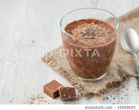 Chocolate chia pudding in glass on gray table Chocolate chia pudding in glass on gray table 38989695
