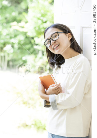 Girl with glasses holding a book Girl with glasses holding a book 38993450