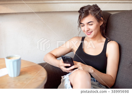 Woman sitting at the table with cup of coffee 38995698