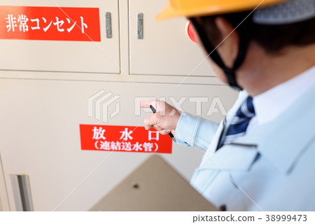 Worker checking fire protection equipment of apartment 38999473