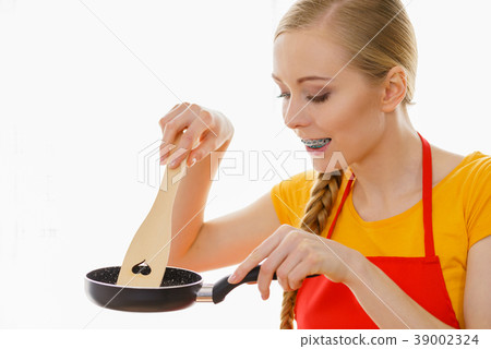 Woman holding cooking utensils 39002324