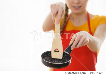 Woman hand holding cooking pan and spatula 39002325