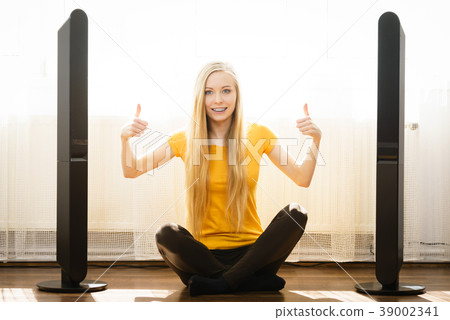 Woman next to speakers at home Woman next to speakers at home 39002341