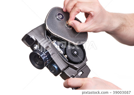 Retro mechanical movie camera in hands of operator 39003087