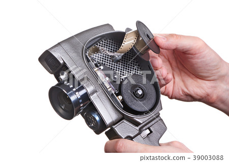 Retro mechanical movie camera with film in hands Retro mechanical movie camera with film in hands 39003088