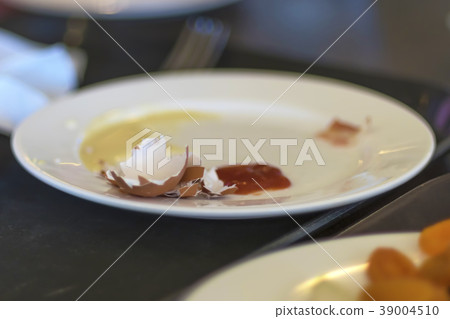 Dirty plate with leftover food and eggshell after Dirty plate with leftover food and eggshell after 39004510
