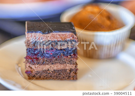 A piece of chocolate cake on a plate and a soft A piece of chocolate cake on a plate and a soft 39004511