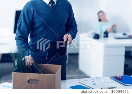 Close up of mature man packing office supplies in 39004921