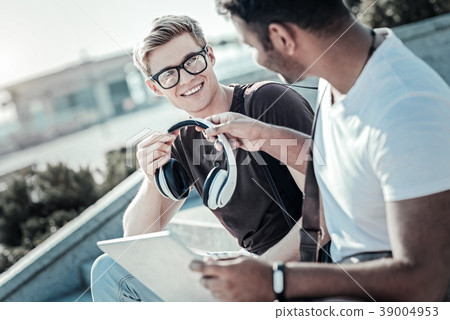Joyful positive man taking headphones 39004953