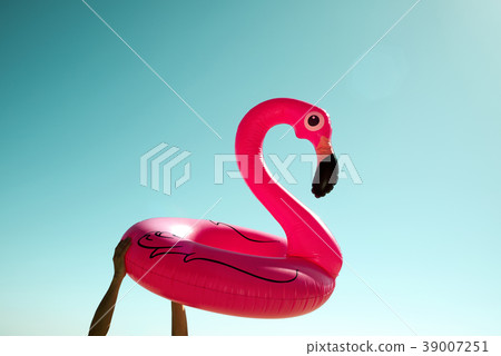 man with a pink flamingo swim ring 39007251